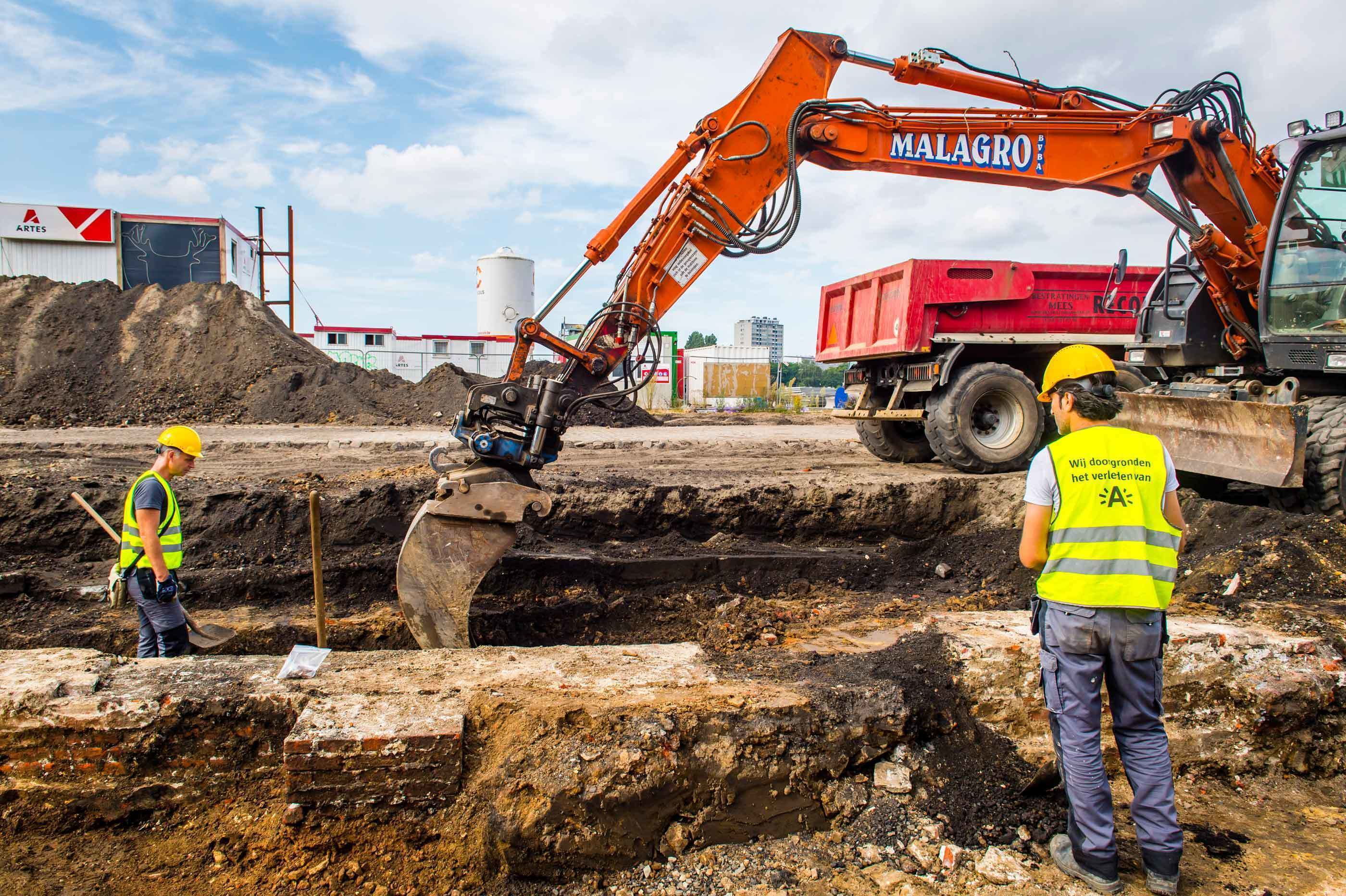 Archeologen begeleiden het kraanwerk zodat het vlak op het juiste niveau aangelegd wordt.