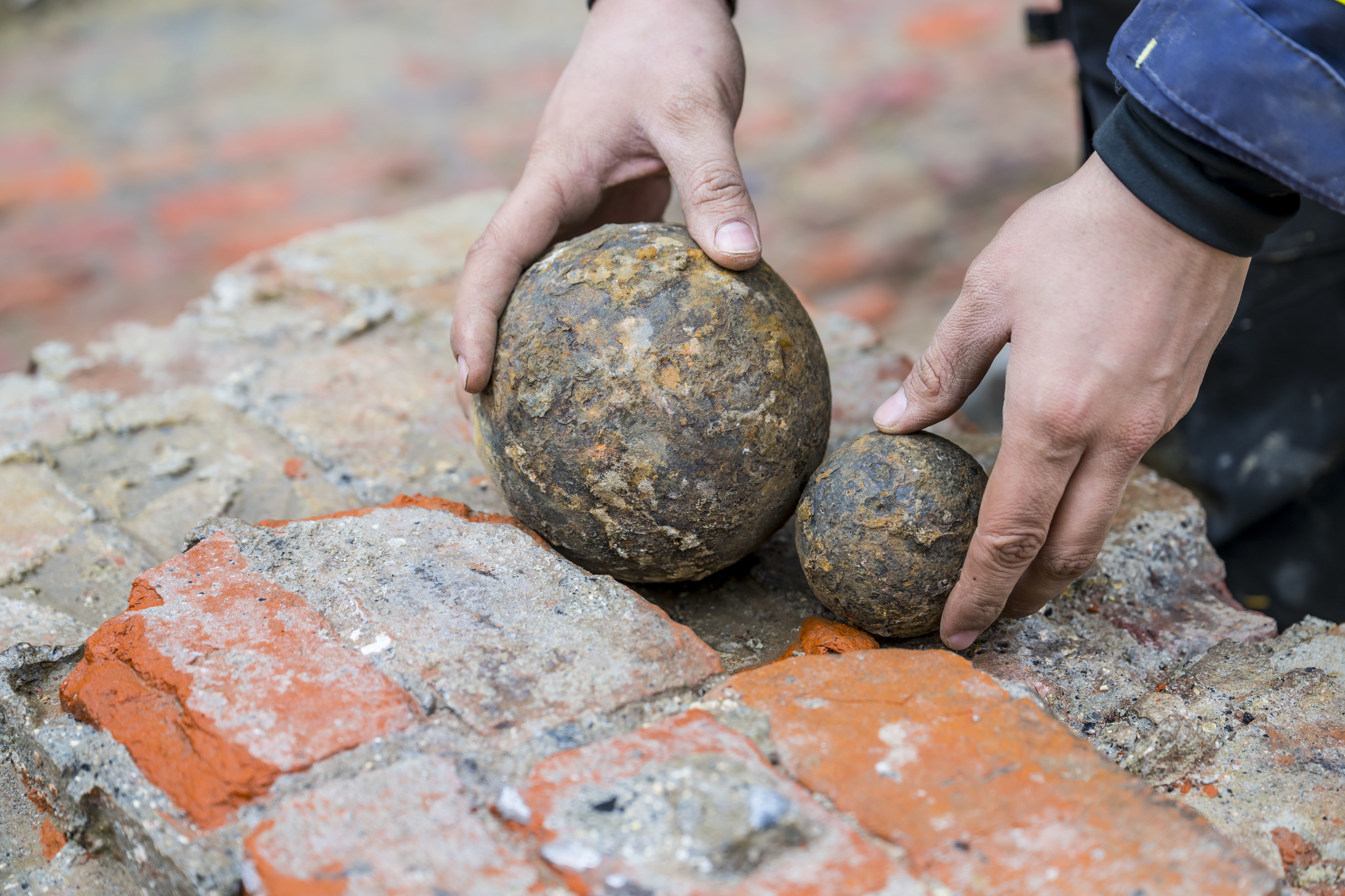 2massieve ijzeren kanonskogels, duidelijk van een verschillend kaliber.