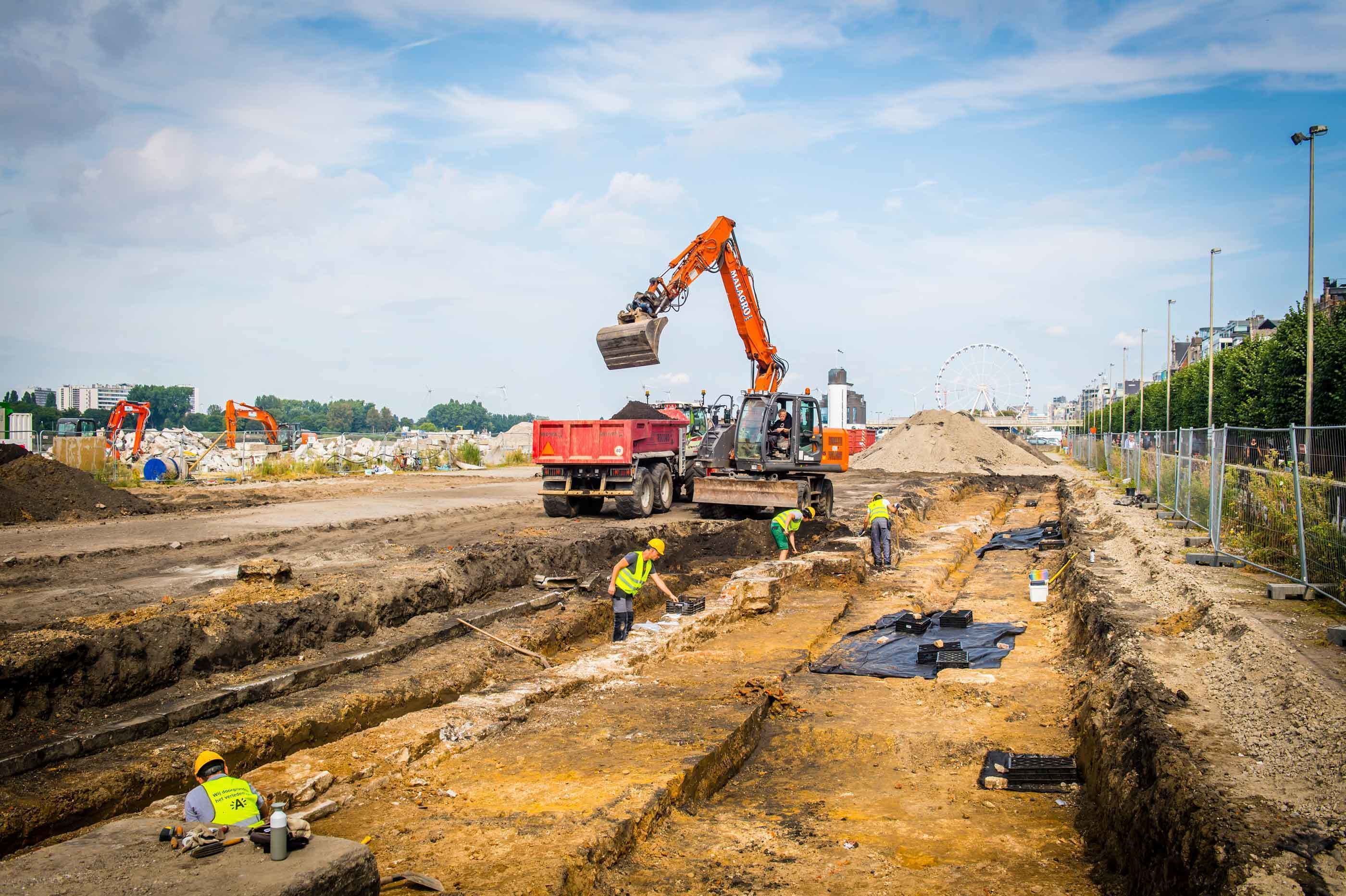 De opgravingszone van fase 1 wordt opengelegd met de kraan.
