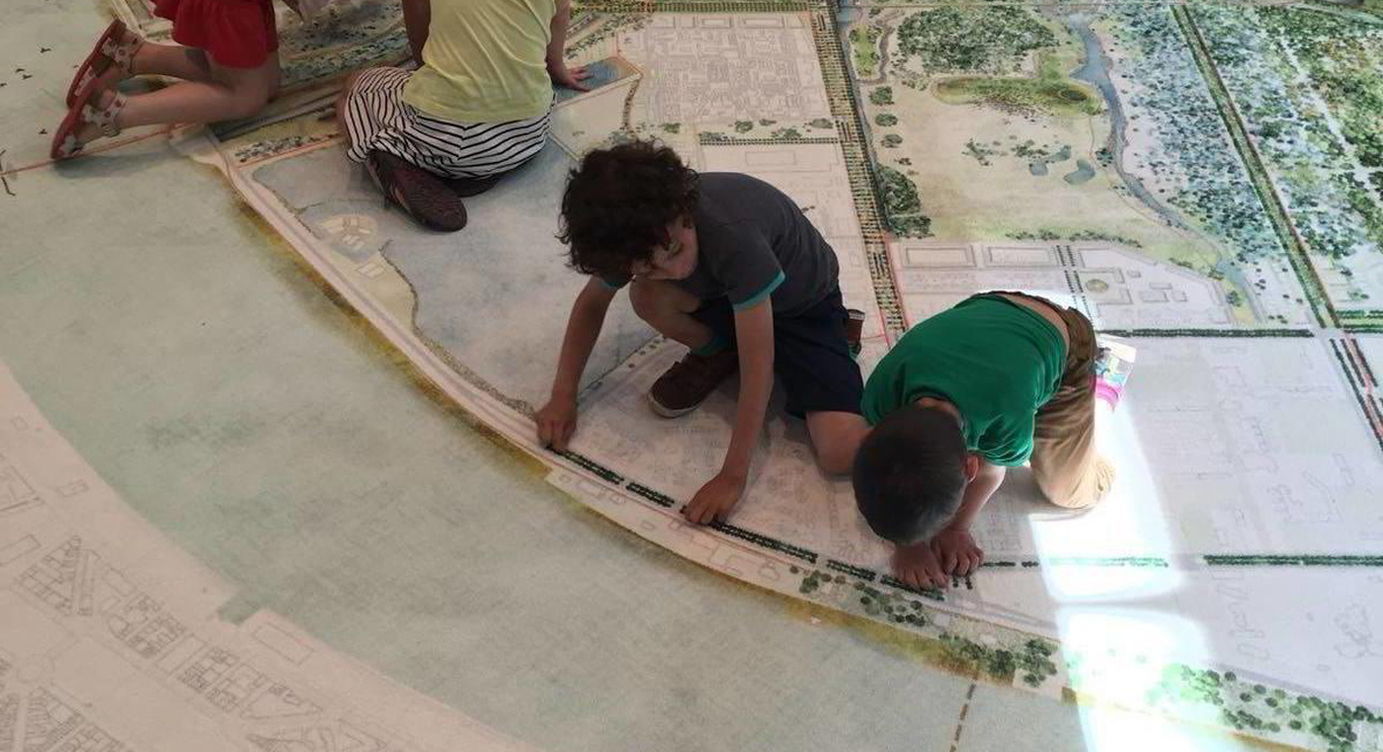Kinderen aan het spelen op de maquette van Team West