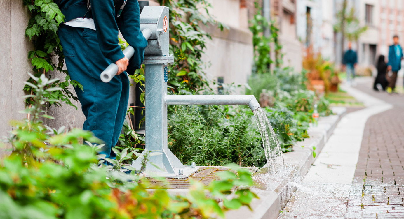 Lange Riddersstraat: met een handpomp kan regenwater opgepompt worden uit een ondergronds reservoirom plantvakken te bevloeien of om te spelen op warme dagen