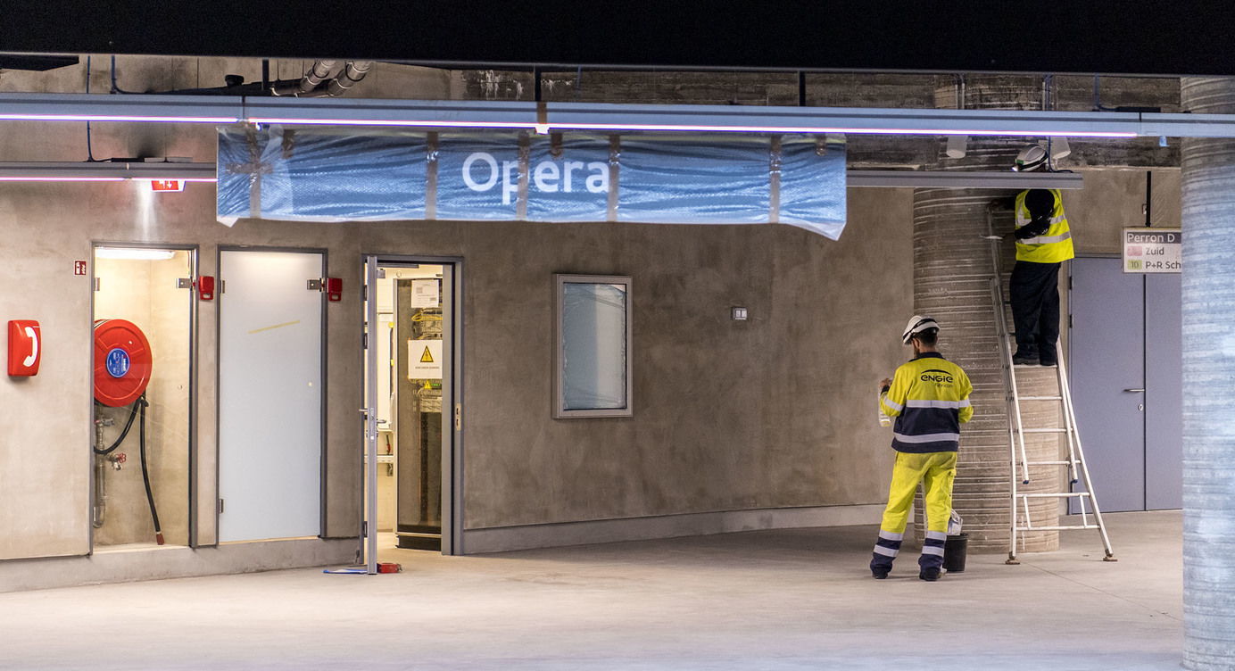 Arbeiders hangen signalisatie op in premetrostation Opera