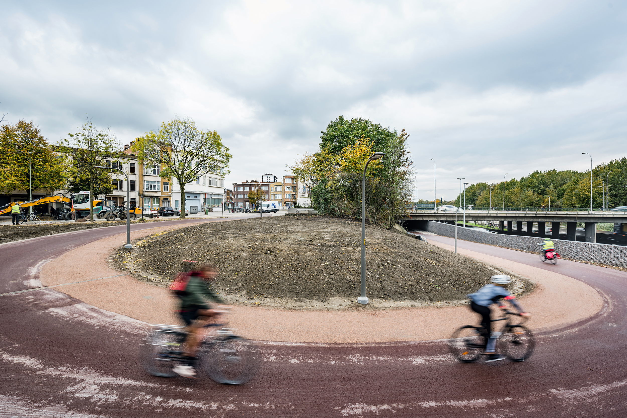 Via een grote bocht komen fietsers vanop de Collegelaan onder de Stenenbrug.