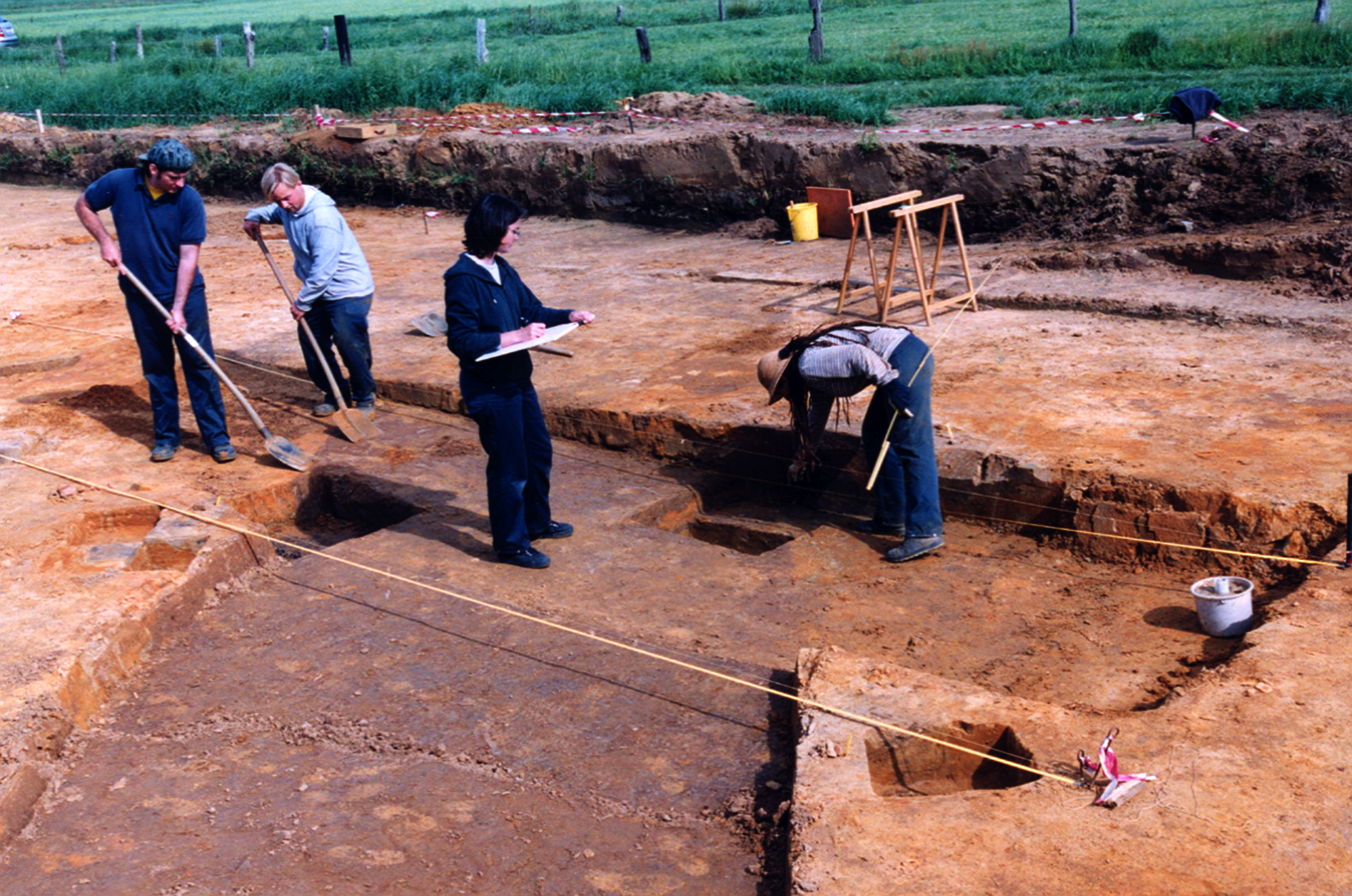Archeologen tekenen het opgravingsvlak in.