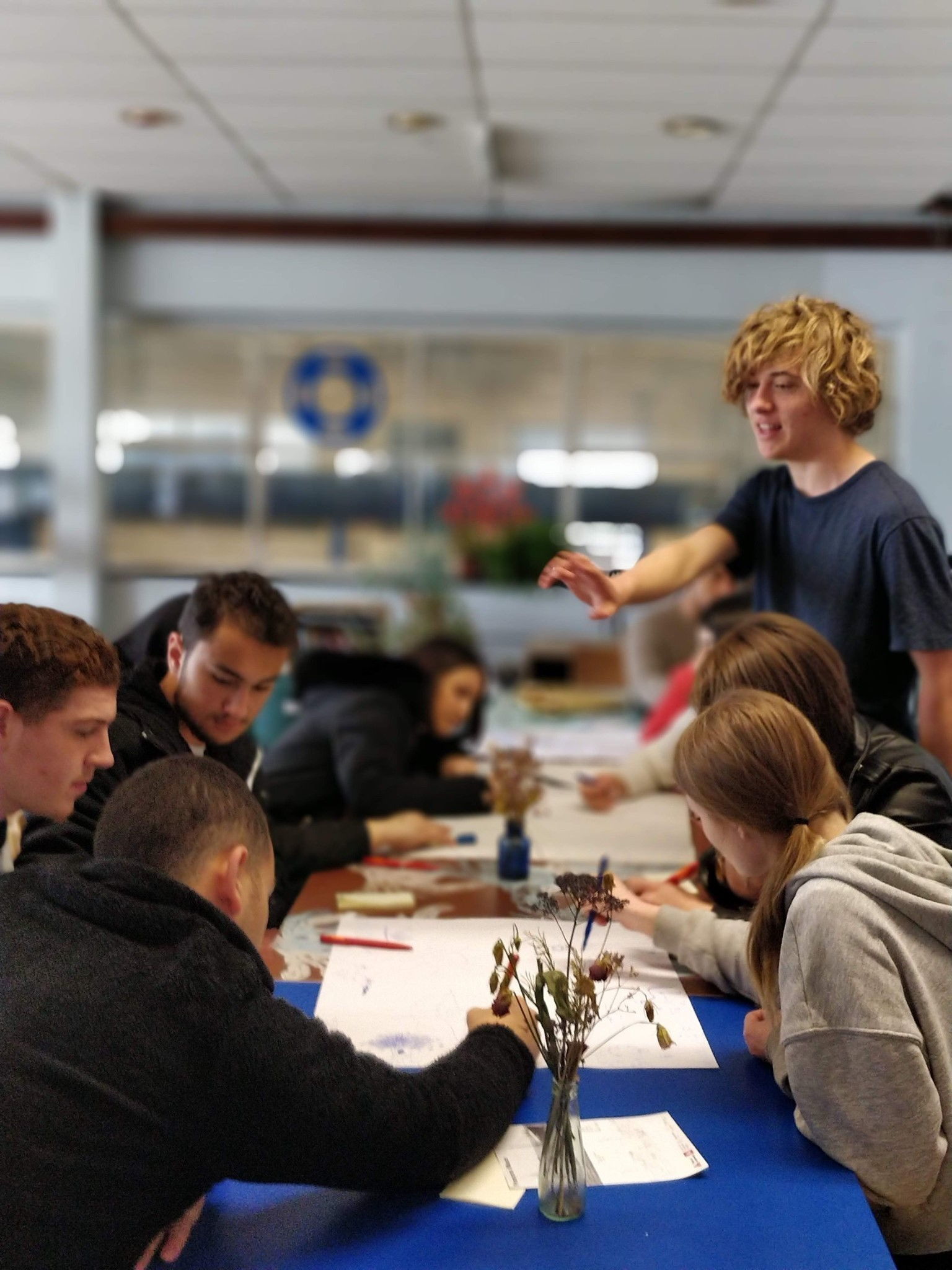 Jongeren zitten samen aan tafel om hun droomstad te creëren