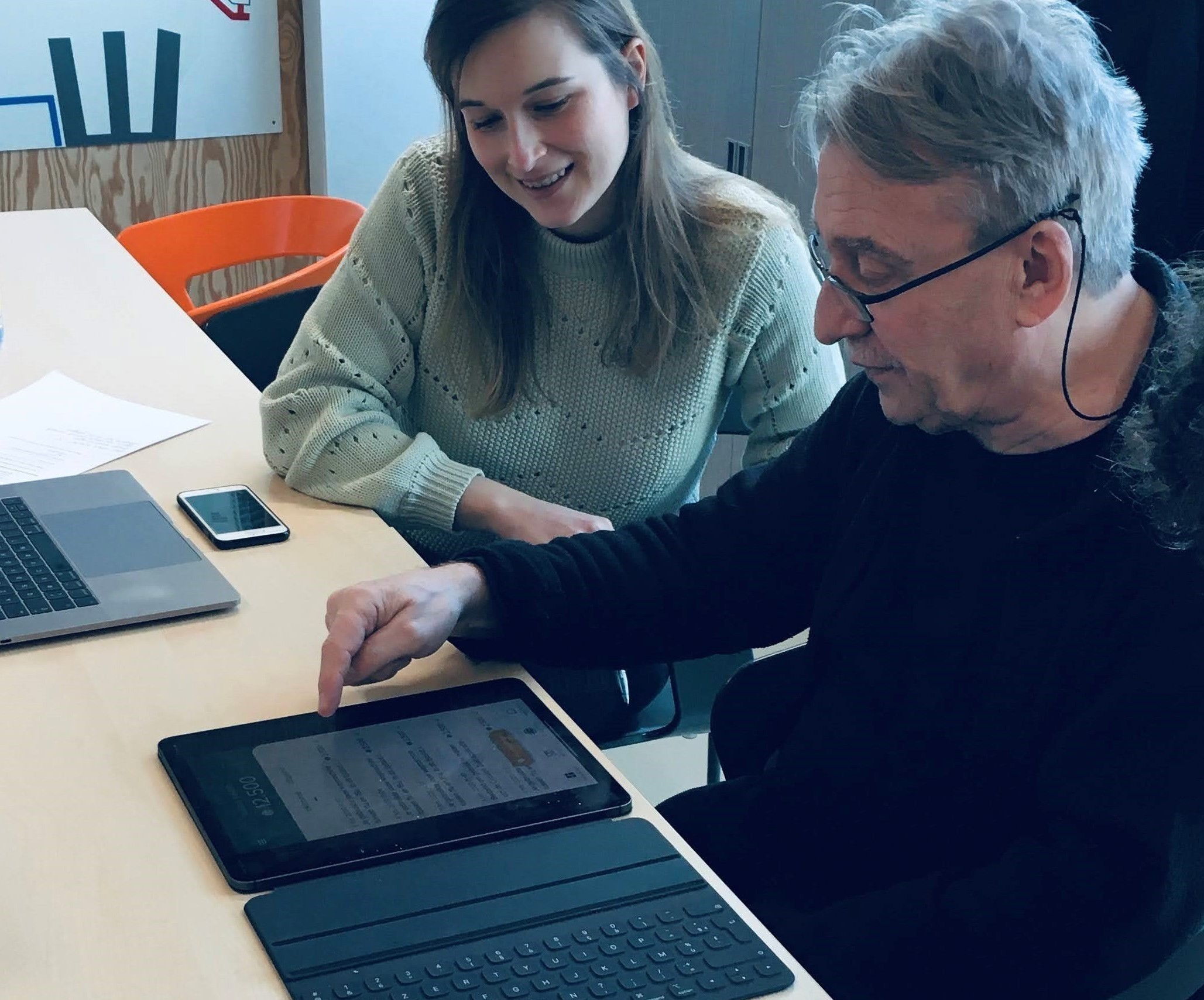 Expert van imec legt uit hoe de app werkt aan een bewoner.