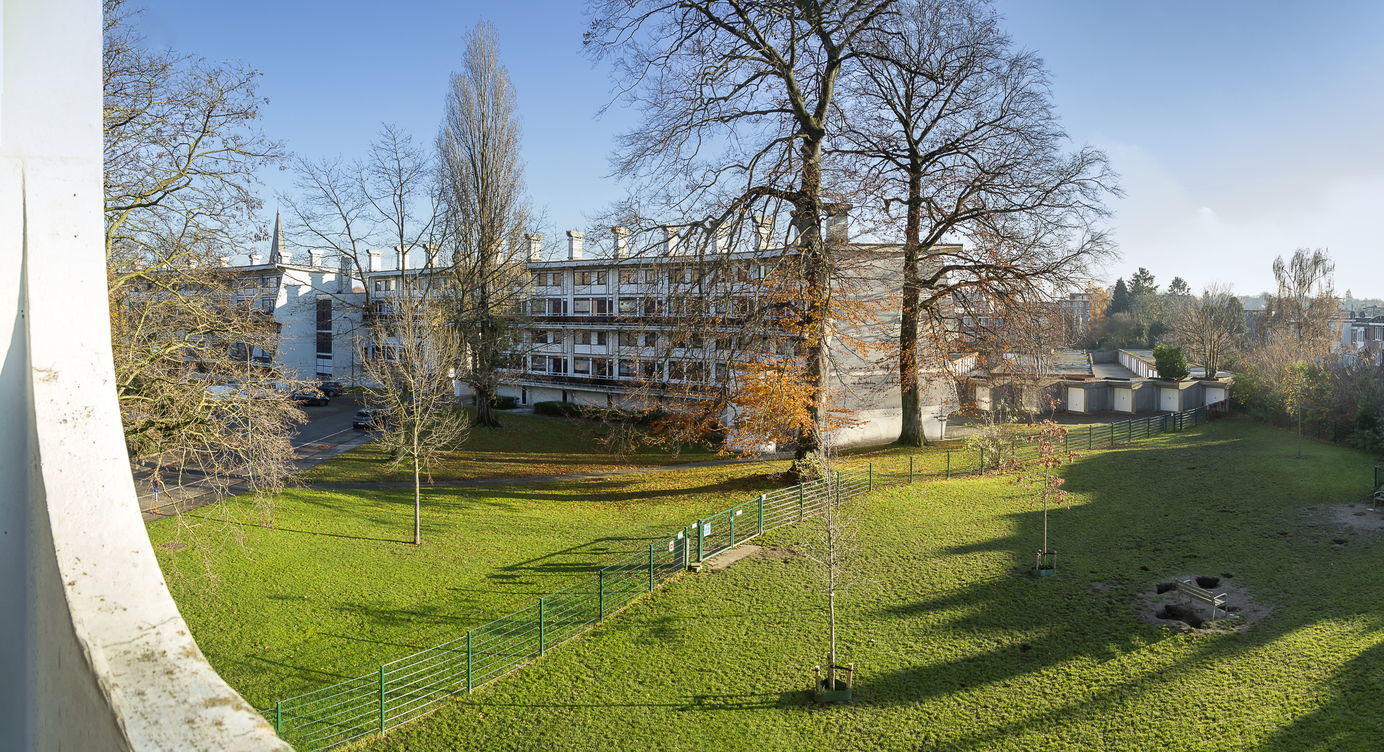 Zicht op het openbaar domein en een van de gebouwen van architect Renaat Braem in de zuidrand van de Arenawijk in Deurne-Zuid